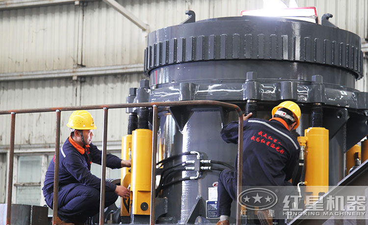 工作人員檢測圓錐破碎機(jī)，保障生產(chǎn)的設(shè)備都有高質(zhì)量